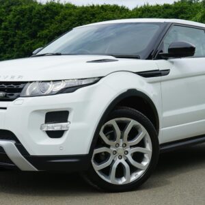 Stylish white Range Rover parked on a road in a green outdoor setting, showcasing its luxury design.