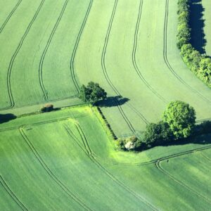 Aerial photograph showcasing lush green fields and trees in Bréhal, Normandie, France.