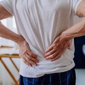 Man holding lower back in pain while standing